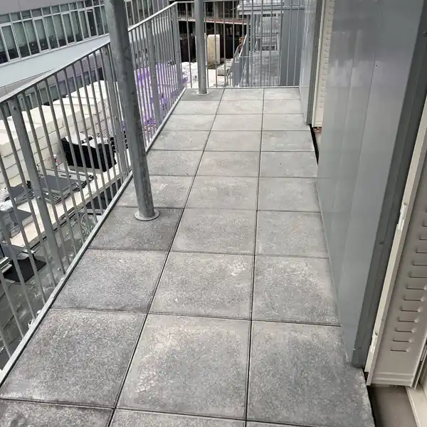 Terrasse d'appartement en dalles sur plots après étanchéité, garde-corps et seuil de baie traités