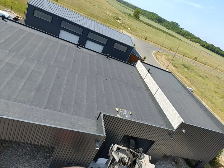 Bâtiment tertiaire neuf à Versailles : toit terrasse étanchée et versants en panneaux sandwich posés par France Pro Étanchéité