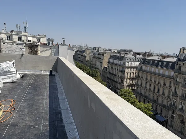 Membrane bitumineuse soudée avec ses relevés sur la toiture-terrasse à Paris 8e, toits de Paris en arrière-plan