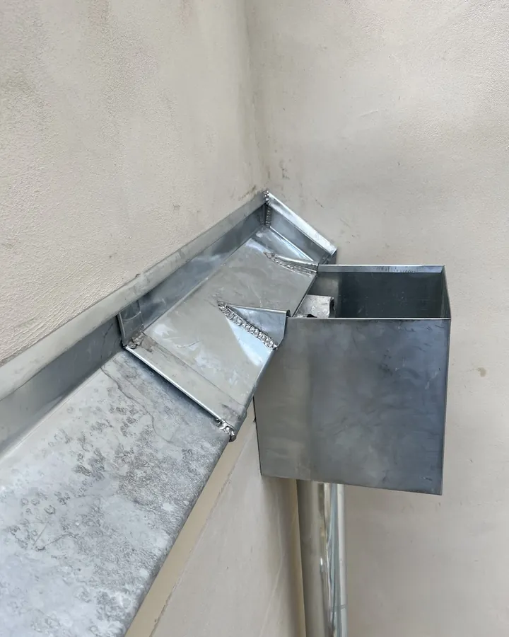 Évacuation des eaux pluviales raccordée à l'étanchéité d'une toiture parisienne