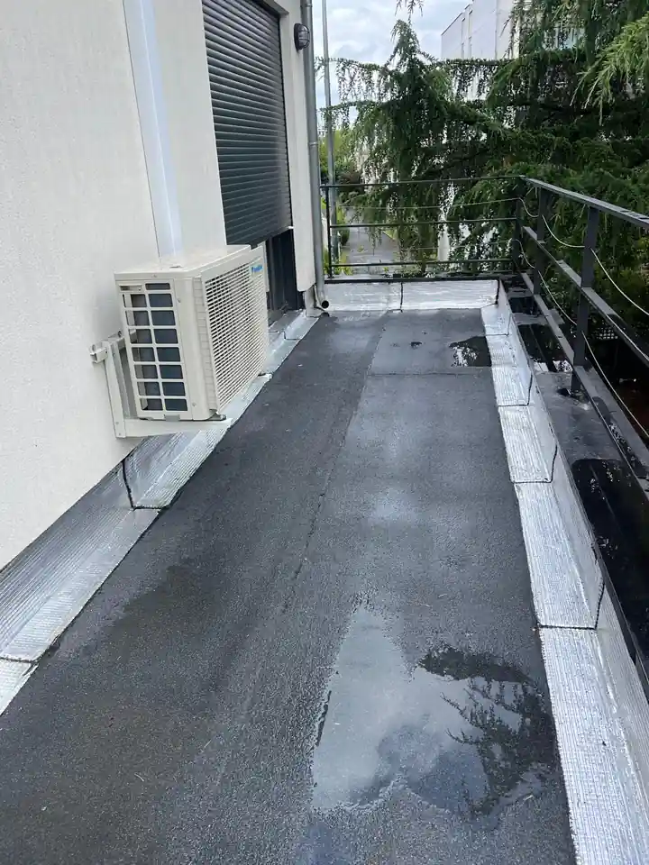Terrasse d'appartement à Paris après étanchéité, membrane bitumineuse neuve, relevés contre le mur et autour de l'unité de climatisation