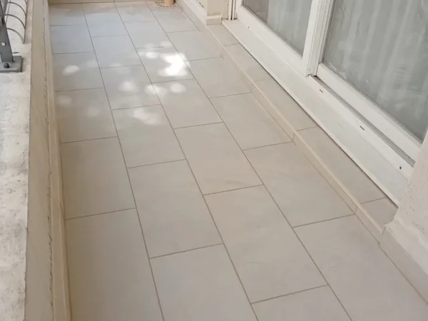 Terrasse carrelée en grès cérame avec seuil de porte-fenêtre après les travaux d'étanchéité