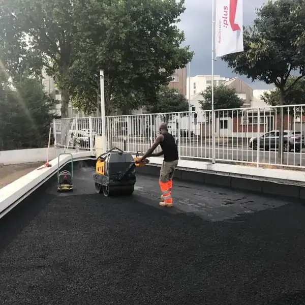 Compactage de l'enrobé sur le toit terrasse carrossable d'une concession automobile à Nanterre