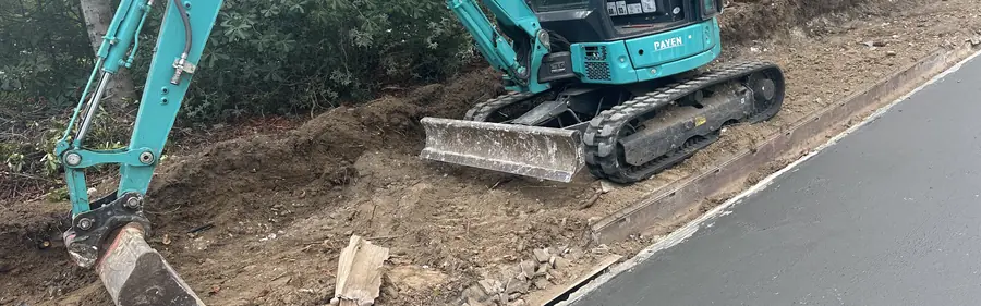 Terrassement à la mini-pelle le long d'un mur enterré, avant la pose de l'étanchéité