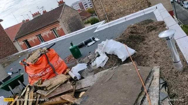 Chantier de dépose sur un toit terrasse parisien, gravats, big-bag et brouette au milieu du gravillon