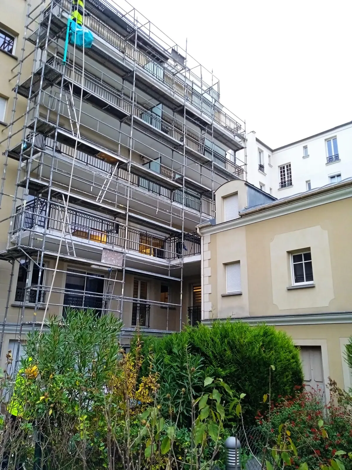 Échafaudage monté sur la façade d'un immeuble habité pendant un chantier