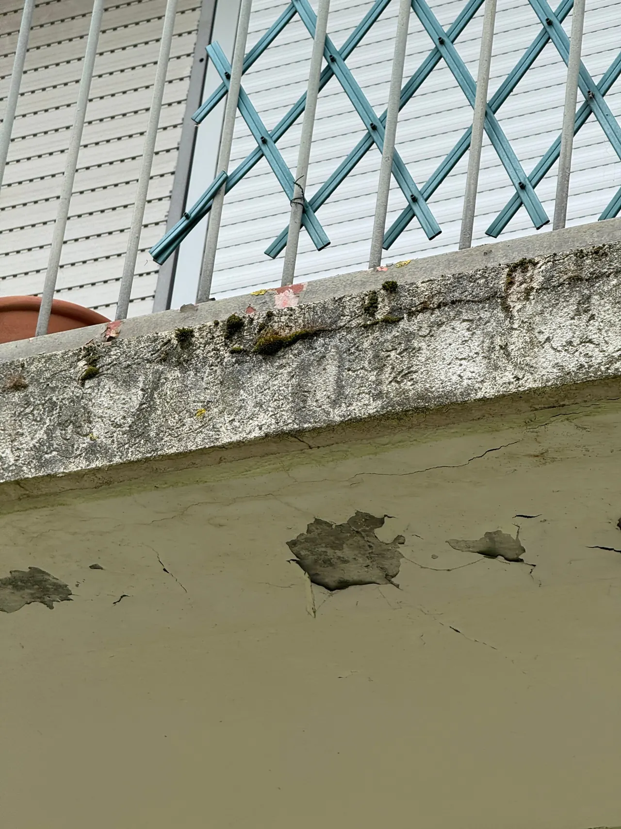 Sous-face de balcon en béton dégradée et nez de dalle fissuré sur un immeuble en copropriété