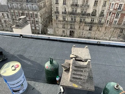Matériel d'étanchéité bitume sur un toit terrasse : primaire, bouteilles de gaz et dalles de protection