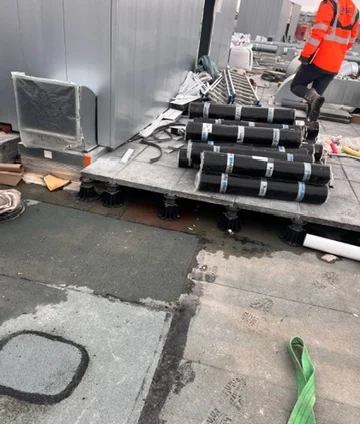 Rouleaux de membrane bitume montés et stockés sur un toit terrasse parisien avant la pose de l'étanchéité