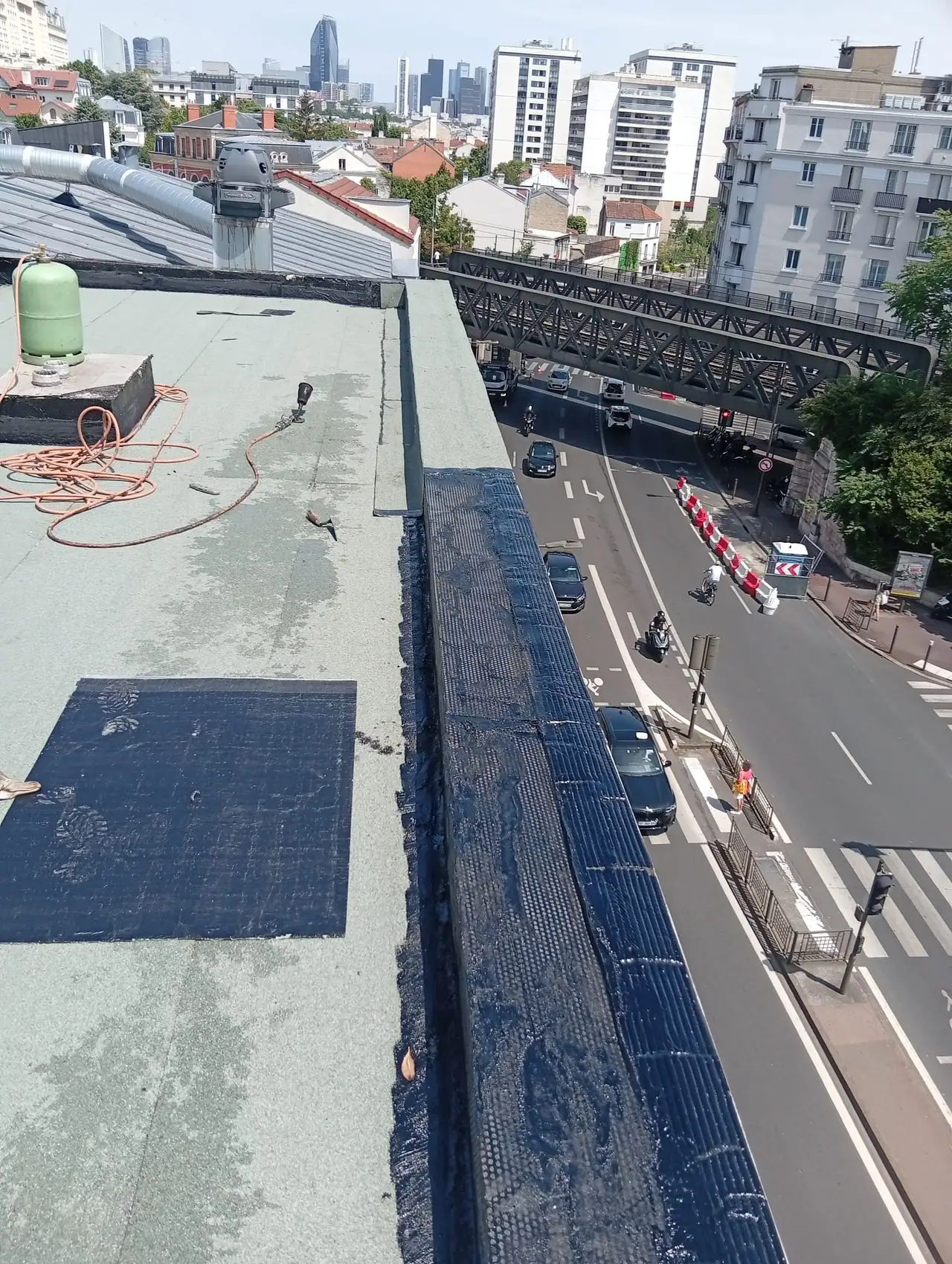Toit terrasse en cours de travaux d'étanchéité surplombant un boulevard de la petite couronne