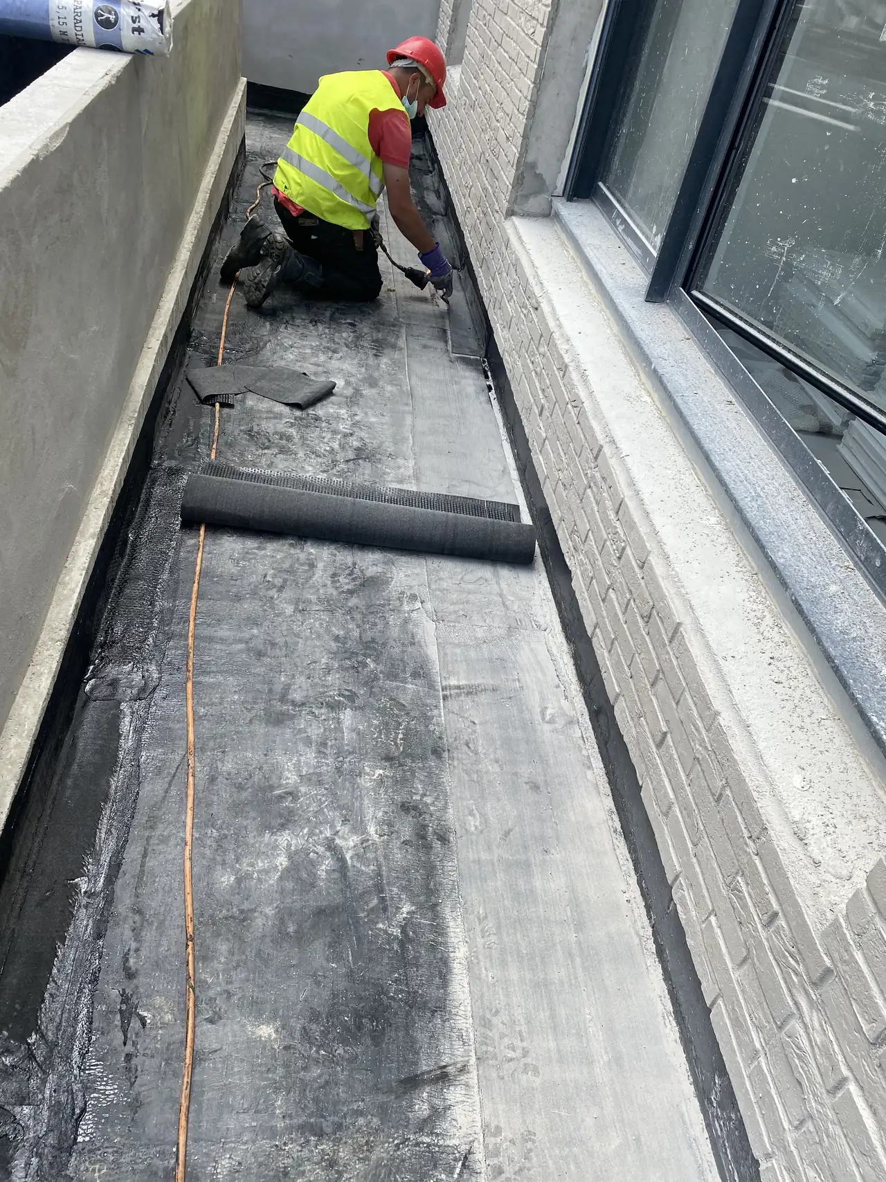Étancheur de France Pro Étanchéité soudant une membrane bitume en relevé sur un toit terrasse parisien