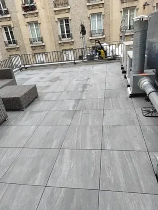 Terrasse carrelée en grands carreaux sur le toit d'un immeuble parisien