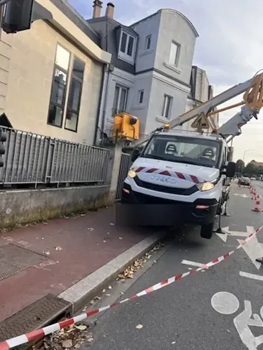 Camion nacelle installé sur une chaussée neutralisée devant un immeuble